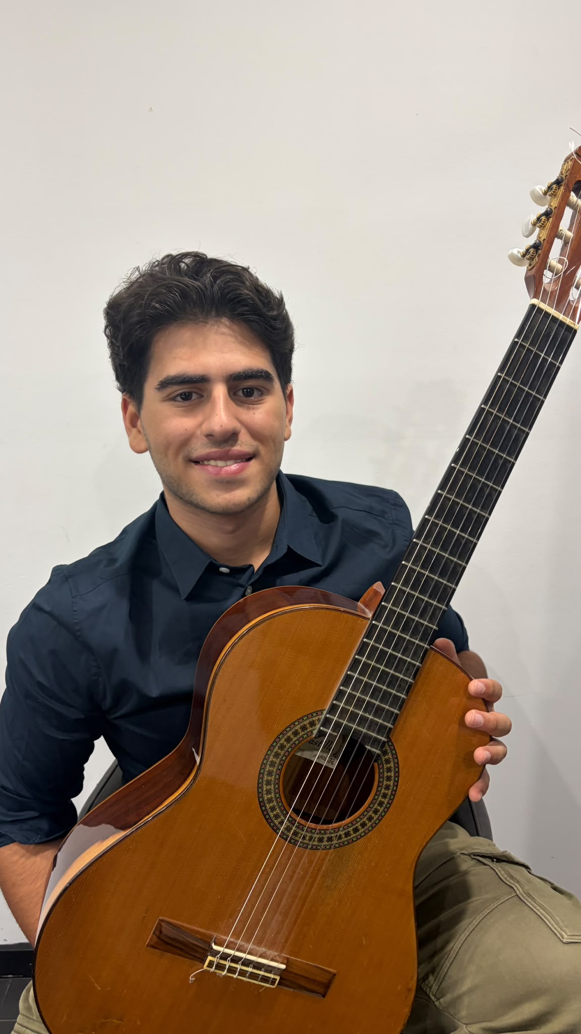 Sam Morgan smiling with his classical guitar
